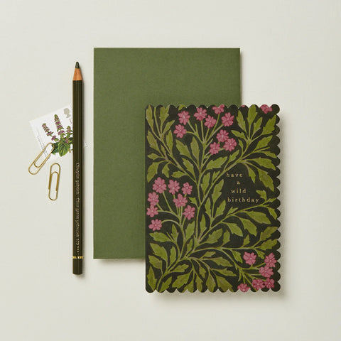 Green notebook with floral design and pencil on a light background