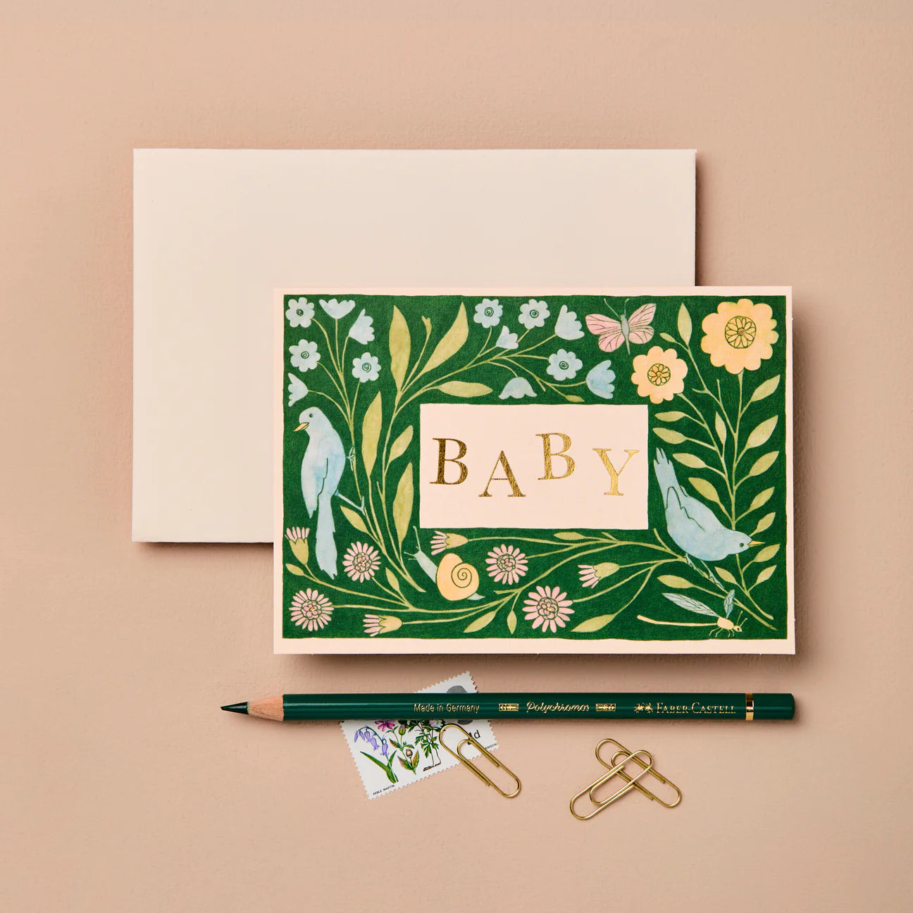 Decorative baby card with floral design and gold 'BABY' text on a beige background