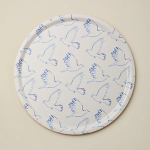 Round tray with blue line art doves against a beige background