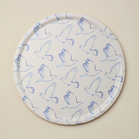 Round tray with blue line art doves against a beige background