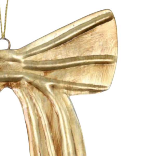 Close up of a section of a gold bow-shaped decoration on a white background