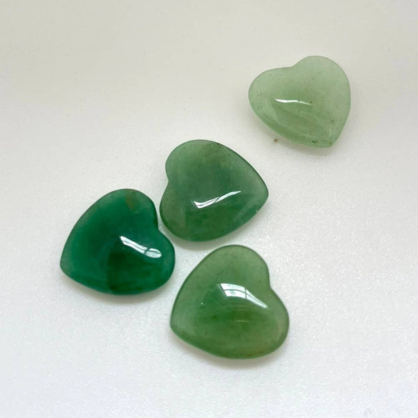 Four green aventurine heart-shaped crystals on a white background
