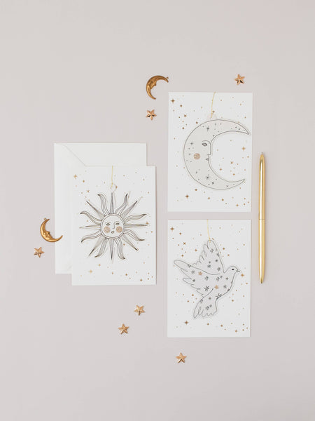Paper decorations with celestial designs on a light grey background