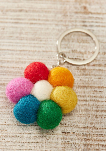 Colourful felt ball flower keychain on a textured surface
