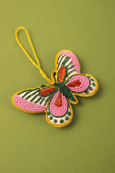 Butterfly-shaped ornament with beadwork on a green background