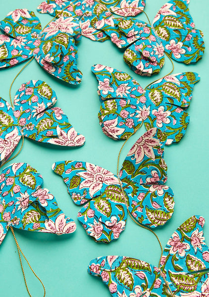 Floral-patterned butterfly decorations on a turquoise background