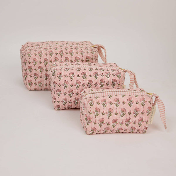 Set of three pink floral-patterned pouches on a white background