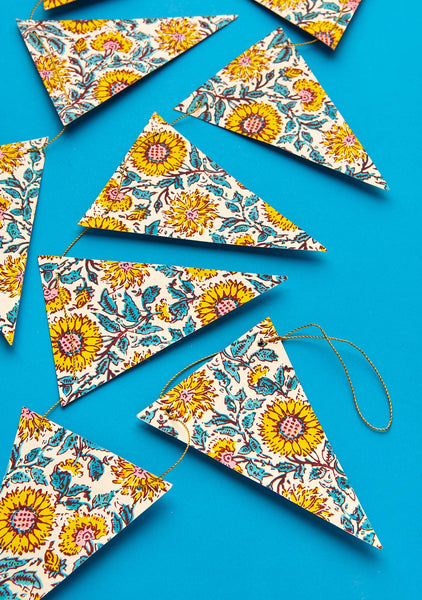 Colourful floral patterned triangle flags on a blue background