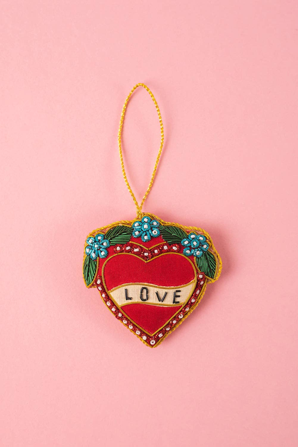 Heart-shaped ornament with 'LOVE' text on a pink background