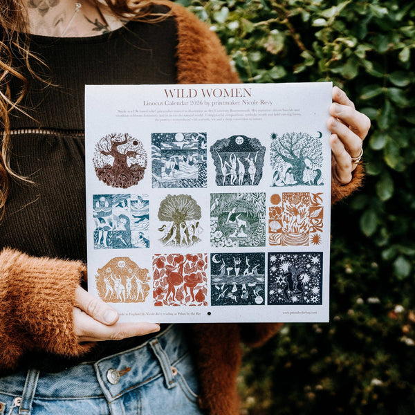 Person holding a 'Wild Women' calendar with nature-themed designs.