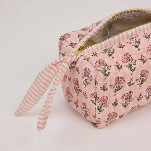 Pink floral-patterned pouch with a striped pull on a light background
