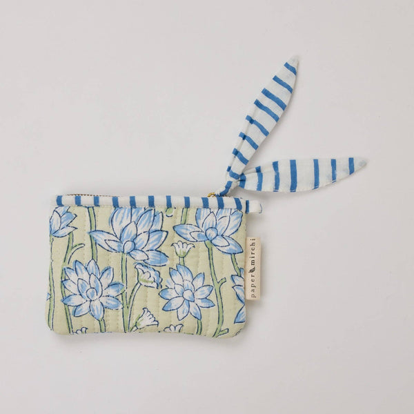 Small fabric pouch with floral design and striped trim on a light background