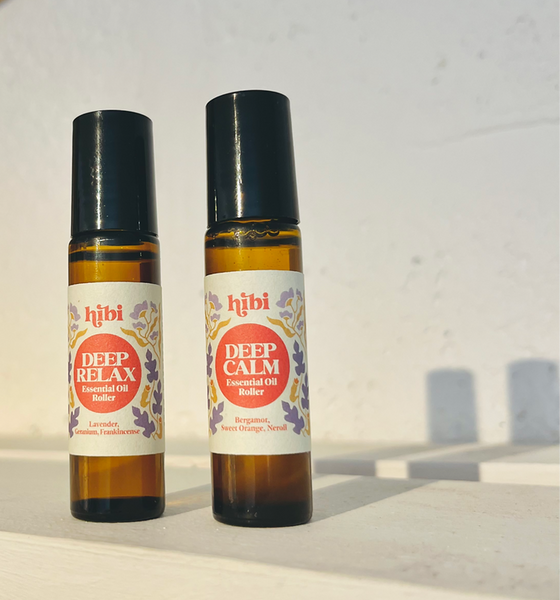 Two bottles of 'hibi' essential oil rollers on a light background