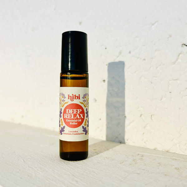 Roll-on bottle of 'Deep Relax' essential oil by Hibi on a textured white surface with a light grey background.