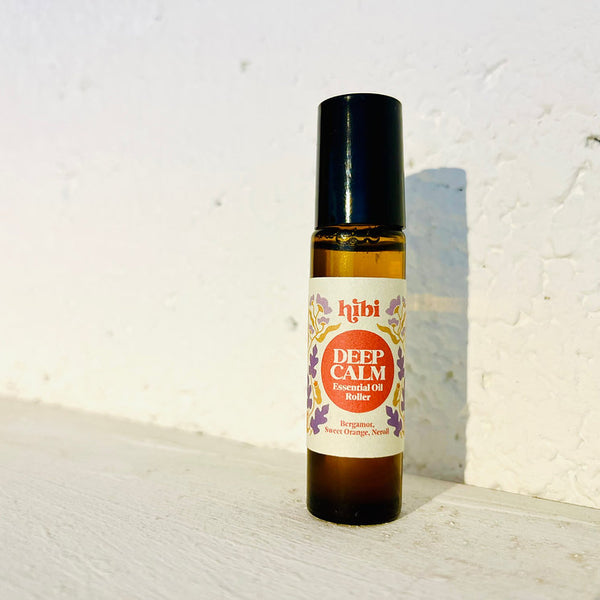 Bottle of HIBI Deep Calm Essential Oil Roller against a white wall