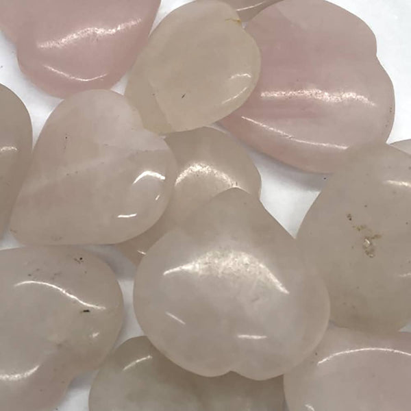 Close-up of heart-shaped rose quartz stones on a white background