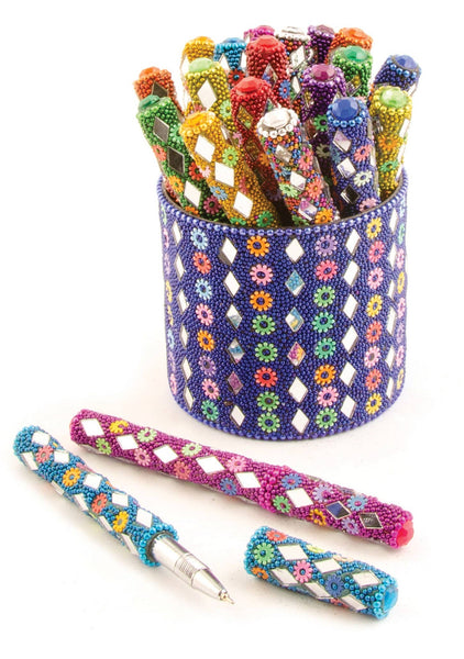 Colourful beaded pens in a decorative holder on a white background