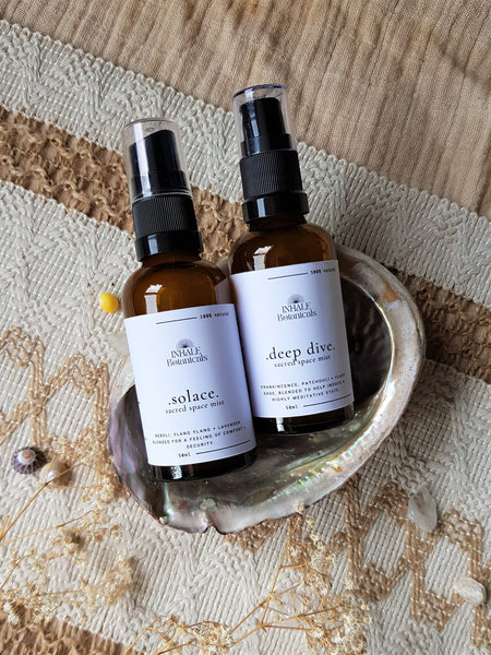 Two brown bottles labeled 'solace' and 'deep dive' on a textured surface.