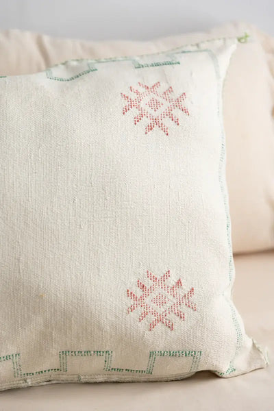 Decorative pillow with embroidered patterns on a beige background