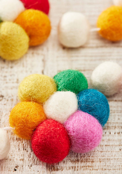 Colourful felt balls on a textured surface