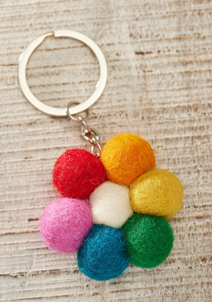 Colourful felt ball flower keychain on a textured surface