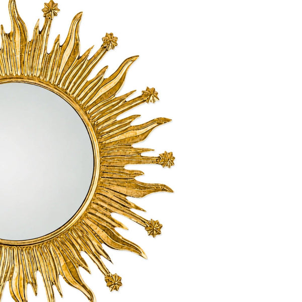 A close-up of a decorative sunburst mirror with a textured gold frame and a reflective mirror center, shown against a plain white background.