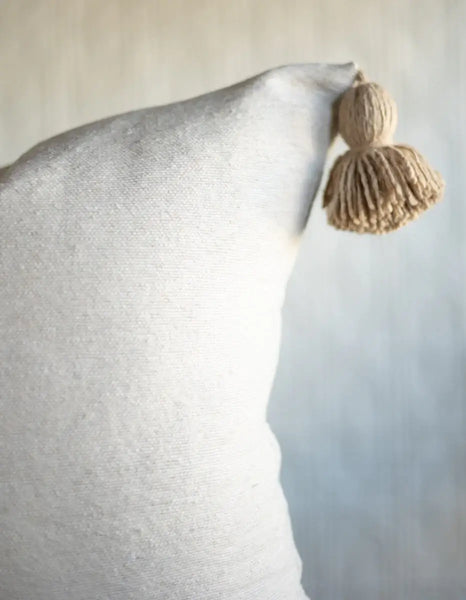 Natural pillow with a textured tassel on a light background