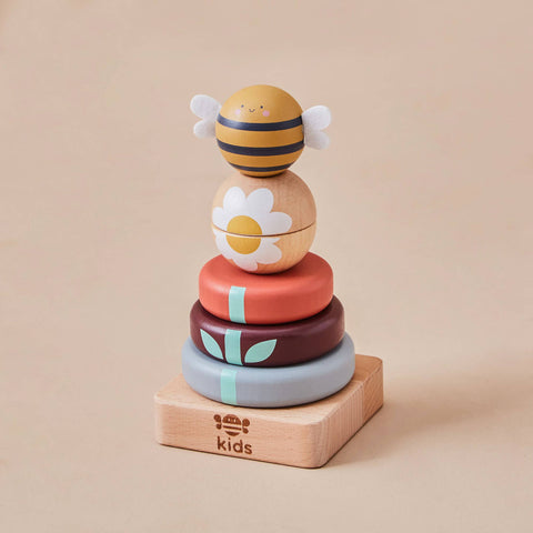 Stack of colourful wooden toys with a bee design on a beige background