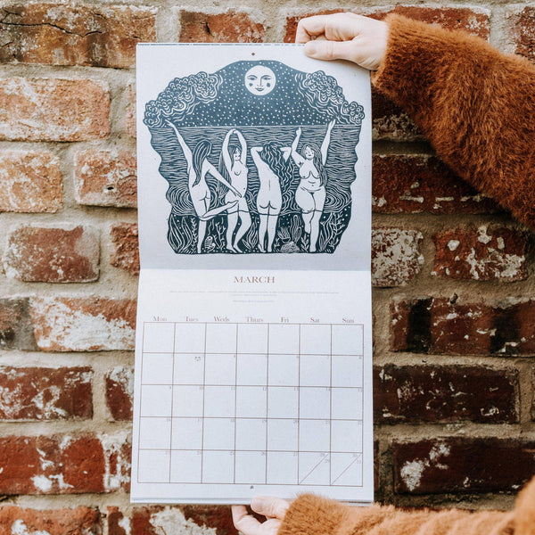 Person holding a calendar with March illustration against a brick wall