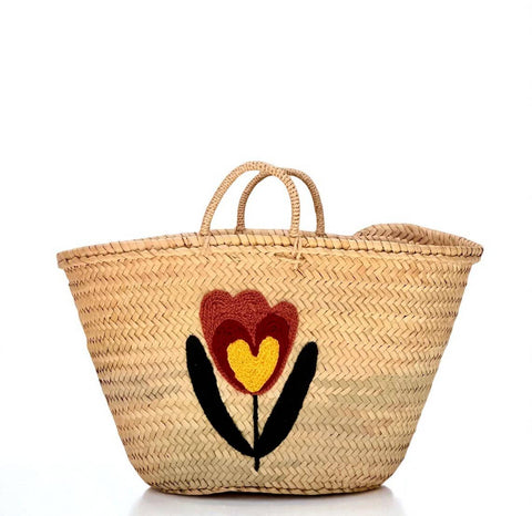 Woven basket with a floral design on a white background