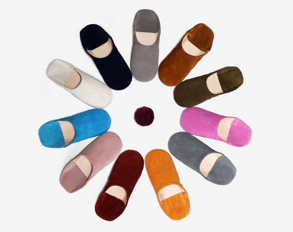 Colorful slippers arranged in a circular pattern on a white background