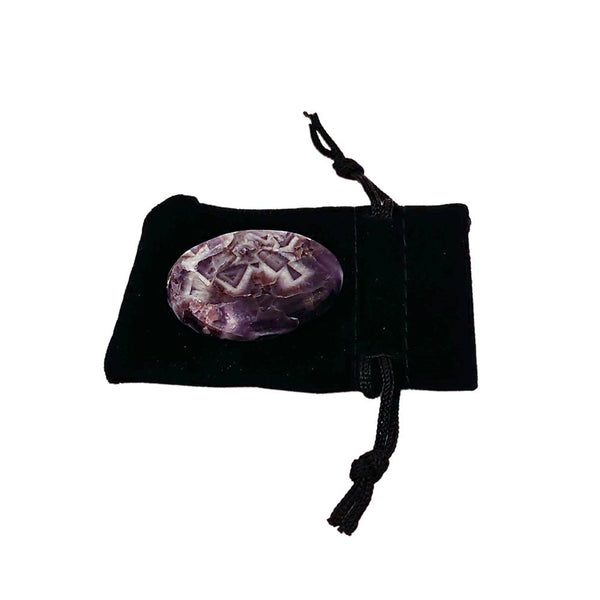 Amethyst crystal on a black drawstring bag against a white background