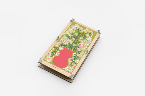 Small wooden flower press with a floral design on a white background