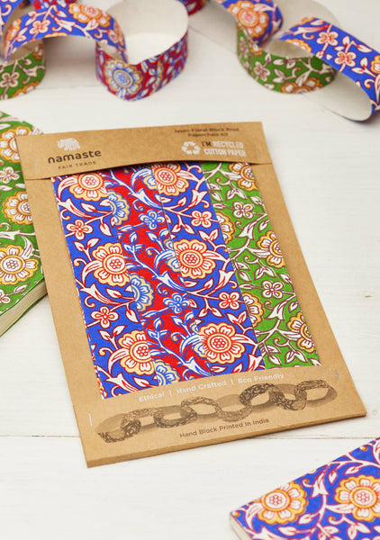 Packaged paper chain decorations with colourful floral designs on a white surface