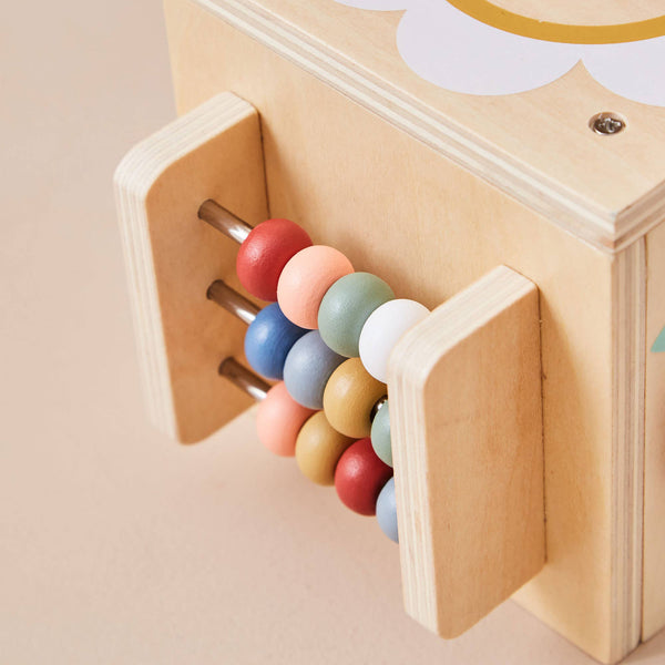 Wooden toy with colorful beads inside a compartment