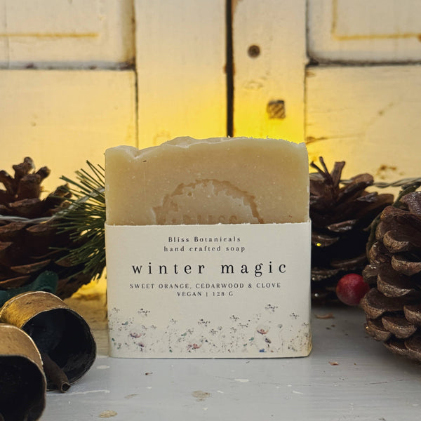 Handcrafted soap bar labeled 'Winter Magic' with decorative elements on a wooden background