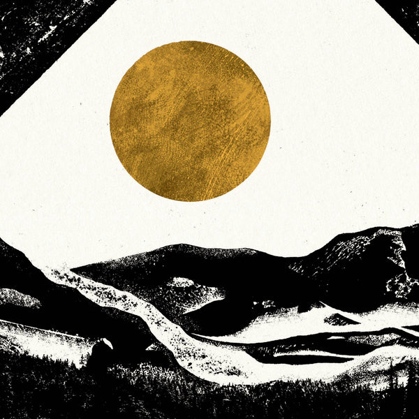 Black and white landscape with a large gold sun in the sky