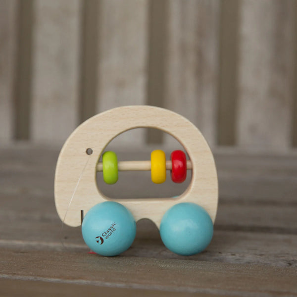 Wooden toy elephant with colourful beads and blue wheels on a wooden surface