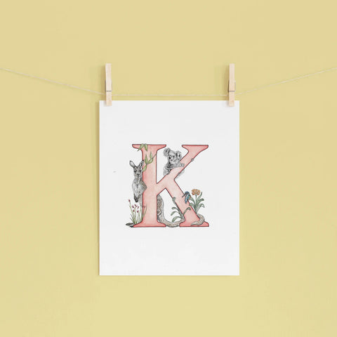 Poster with a decorative letter 'K' design on a yellow wall.
