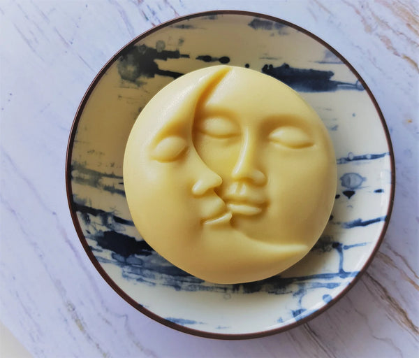 Yellow soap with a face design on a decorative plate
