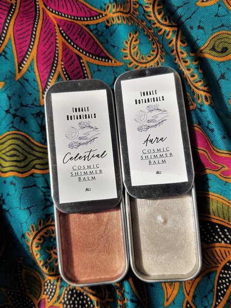 Two balm containers with labels on a colourful fabric background