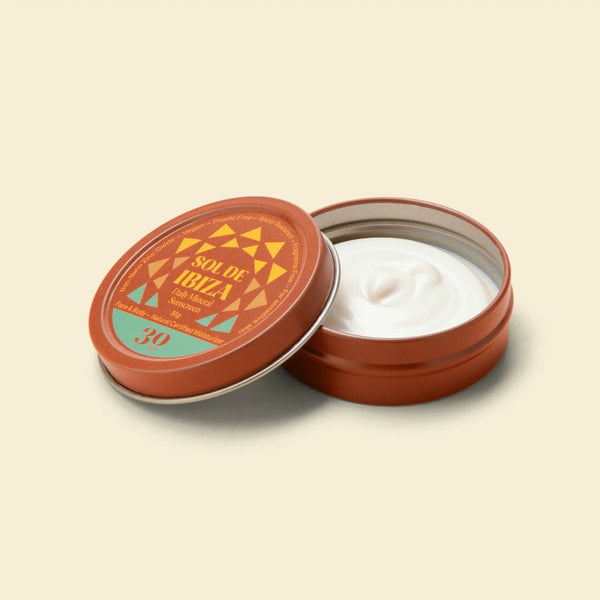 Open Sol de Ibiza sunscreen tin with white cream inside on a beige background