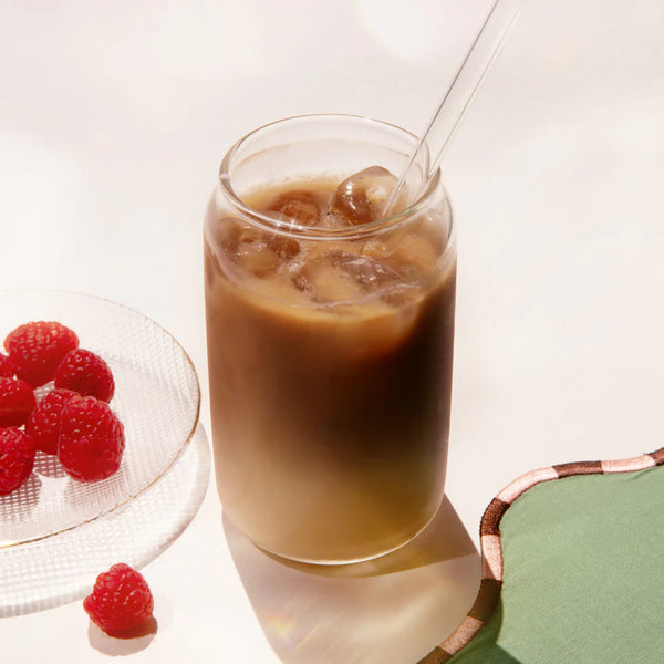 Glass of iced coffee with raspberries on a white background