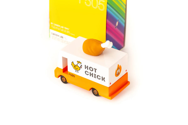 An orange wooden toy van with a 'Hot Chicken' text label and a rubber drumstick topper designed to look like a chicken.